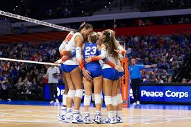 Women's indoor volleyball match on a full court, similar to the Spikes Under the Lights setup